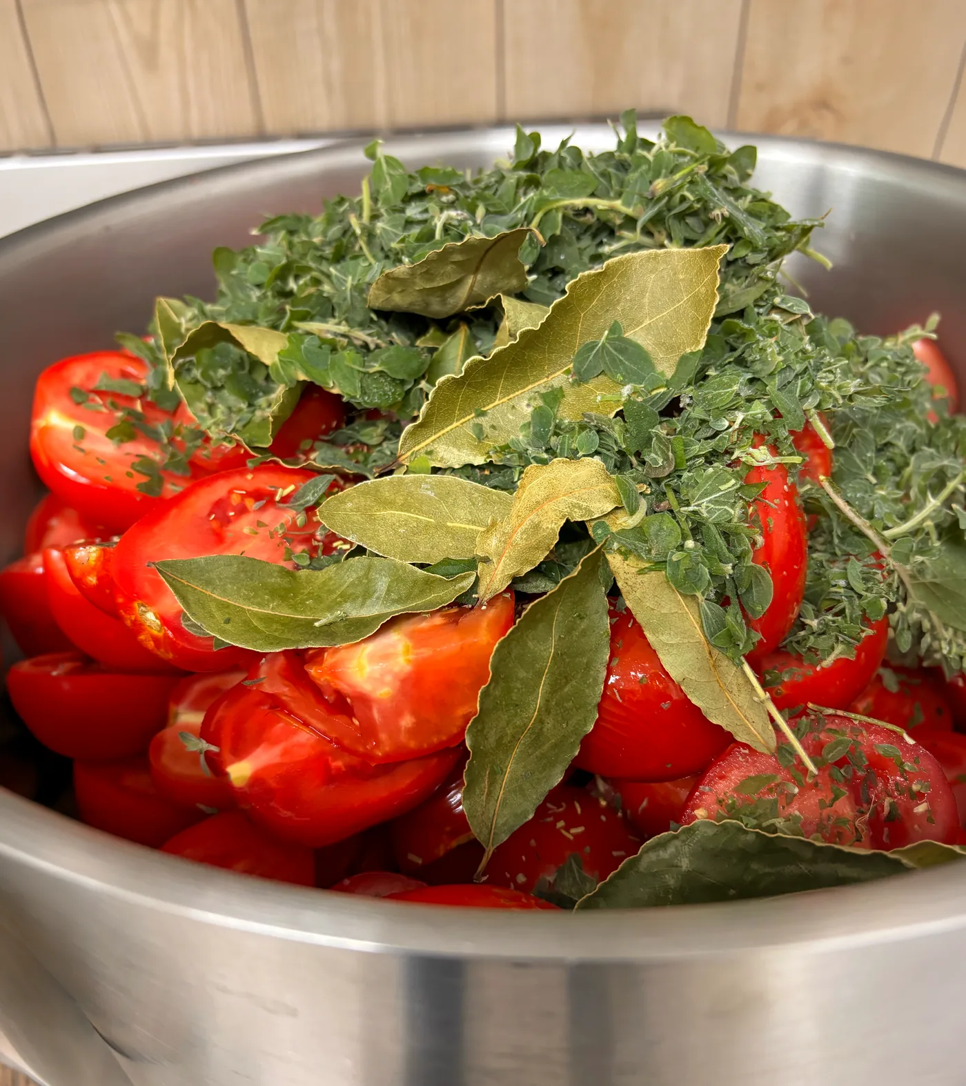 Tomates fraîches et herbes aromatiques (origan, laurier) préparées dans l'atelier de Saint-Jorioz avant mise en bocal.